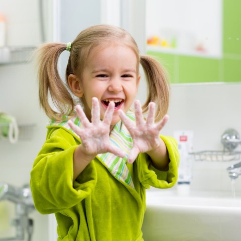 Child washing hands with soap